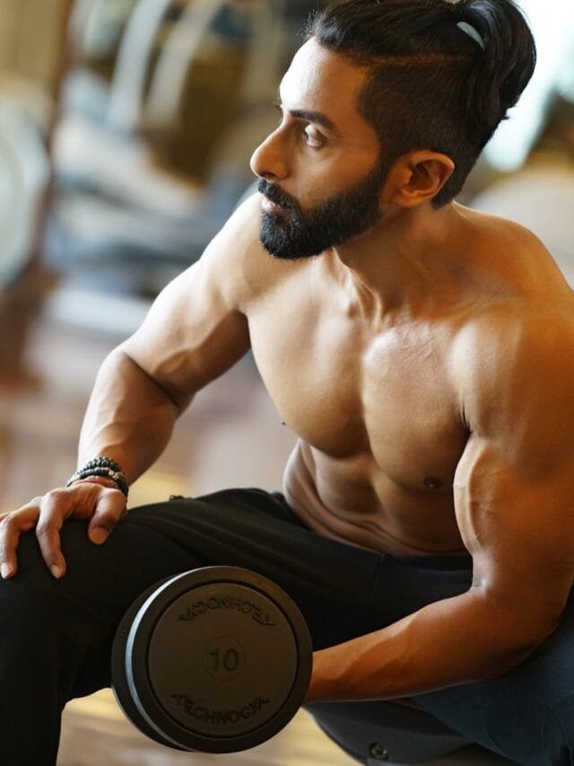 topless man holding dumbbell